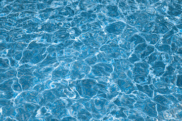 Fototapeta na wymiar Background, water waves in the pool with sun reflection