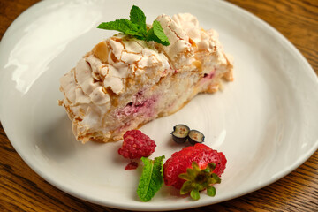Cake with meringue roll with cream and raspberries