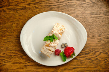 Cake with meringue roll with cream and raspberries