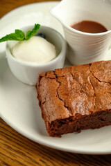 Chocolate cakes on a wooden table with ice cream and mint leaf on top