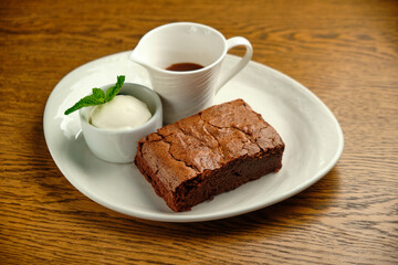 Chocolate cakes on a wooden table with ice cream and mint leaf on top