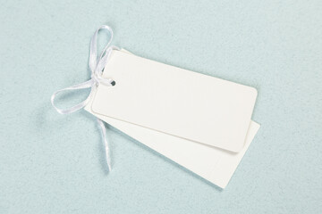 Empty white price tag on a gray-blue background with a soft shadow