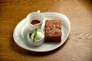 Chocolate cakes on a wooden table with ice cream and mint leaf on top