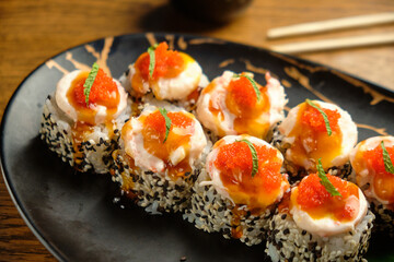 A set of sushi rolls with salmon, caviar, avocado and black sesame in close-up