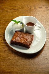 Chocolate cakes on a wooden table with ice cream and mint leaf on top