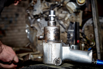 A professional mechanic works on a car engine in a garage. Car service.