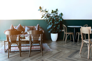 Empty cafe with no people . Coffee shop interior design with chairs and brown leather sofa and green plant nearby