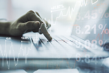 Double exposure of abstract creative financial diagram with hand typing on computer keyboard on background, banking and accounting concept