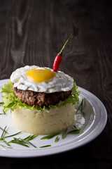 Fried eggs with potatoes and meatballs. Photo of food on a dark background