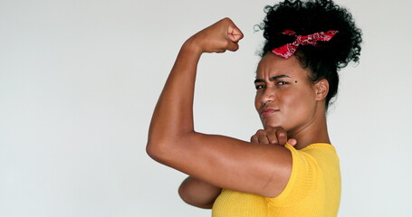 African American feminist woman posing to camera doing we can do it gesture with arm