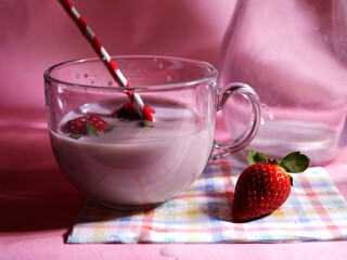 Strawberry milkshake on pink background close up shot 