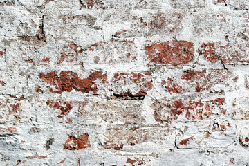 Brick wall covered with plaster and whitewash, restoration of old brickwork
