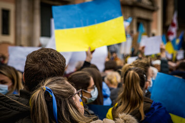 Young Couple Leaning on Each Other at Demonstration in Support of Ukraine with National Flags...