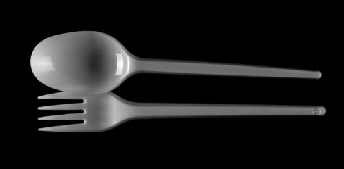 Plastic white fork and spoon isolated on black  