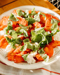 Caprese salad, tomato, mozzarella cheese, basil put on a plate, dish