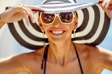 Summer portrait of smiling woman in hat and sunglasses - 501194998