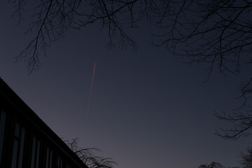 A lonely plane streaking across the night sky high above.