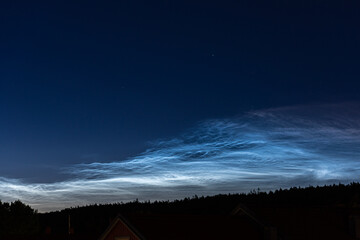 Noctilucent clouds high in the sky at midnight.
