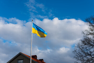 The flag of Ukraine flying proudly by a house.