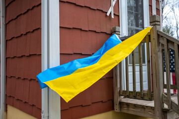 Stand With Ukraine : flying Ukrainian flag on side of house in America in spring 2022