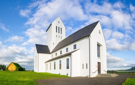 Fish-eye wide angle photo of white Skalholt church in Iceland with blue sky