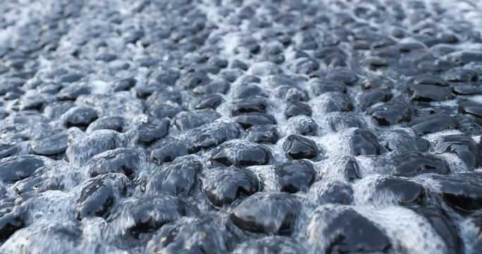 Running water and smooth stones at bottom