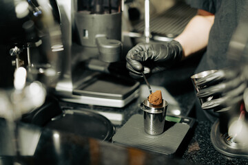 Close-up image of Grind coffee powder in measuring scoop in a Cafe coffee shop or restaurant. Process of Barista making coffee before put coffee powder into brewing machine. Cafe Service Concept