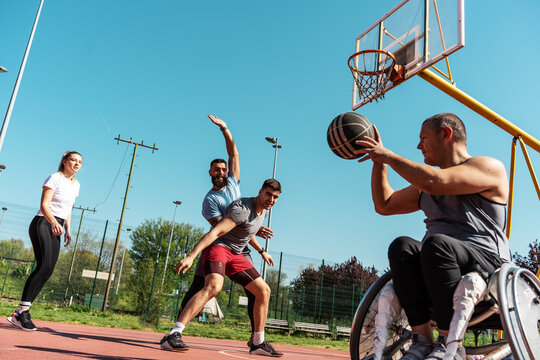  A physically challenged person play street basketball with his friends.		