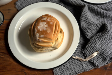 Artisan style cups and plates on wooden table and window light still life with homemade bread on the plates.