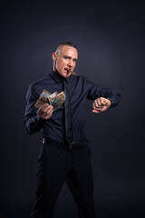 Businessman showing off money in black shirt and tie