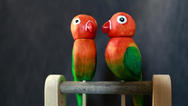 lovebird pair of red parrots twirls their heads 