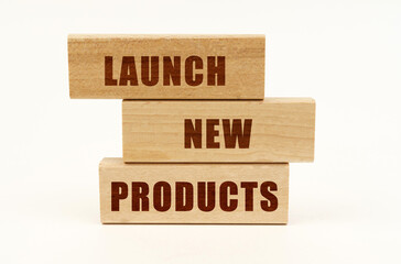On a white surface are wooden blocks with the inscription - Launch New Products