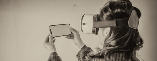 Virtual reality concept. Woman wearing VR helmet and holding smartphone with green screen, isolated on white background