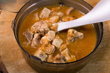 Pieces of meat and broth. Meat goulash in a plastic bowl. Meat dish. Tourist food. Food in tourist...