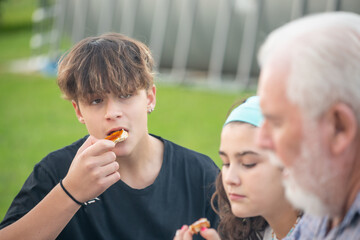 Elderly man eating fig jam on slices of bread outdoor with their