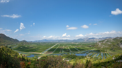 Pižinovac, Croatia - August 28, 2021: Panoramic view of the farm fields in the Neretva river delta, taken with a fisheye lens from the D8 state road between Split and Dubrovnik.