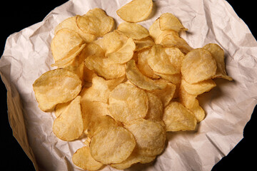 .Crispy potato chips on craft background.