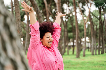 curvy woman with curls taking fresh air in nature. young african american woman in nature taking a break from the city.