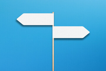 Two blank directional sign on blue background