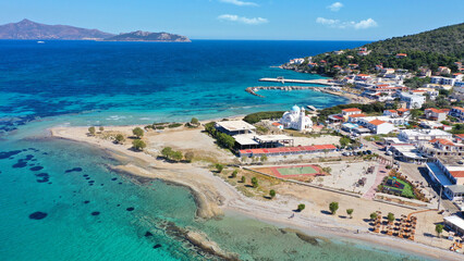 Aerial drone photo of iconic picturesque village, main port and beautiful turquoise beaches of Skala featuring landmark church of Agioi Anargiroi, Agistri island, Saronic gulf, Greece