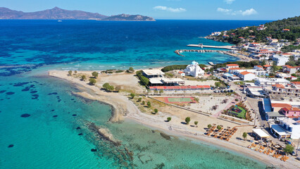 Aerial drone photo of iconic picturesque village, main port and beautiful turquoise beaches of Skala featuring landmark church of Agioi Anargiroi, Agistri island, Saronic gulf, Greece
