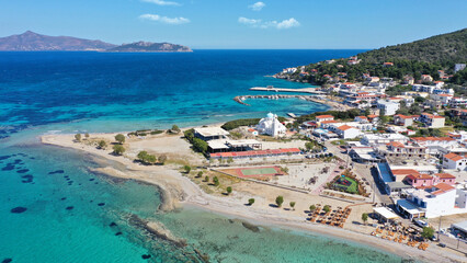 Aerial drone photo of iconic picturesque village, main port and beautiful turquoise beaches of Skala featuring landmark church of Agioi Anargiroi, Agistri island, Saronic gulf, Greece