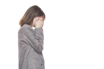 Portrait of a young woman in a jacket holding her hands near her face. Crying, tears, years. Isolated on white background.