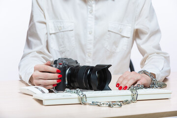 Copyright. The camera is chained to the photographer's hand. The concept of protecting the photographer from theft of his photos. Isolated on white background.