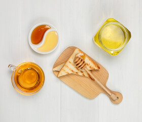 Toast with honey or syrup and a cup of tea. Close-up on a light background. copy of the space