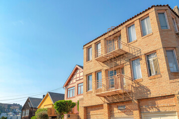 Low angle view of an apartment building with bricks and emergency stairs along the houses