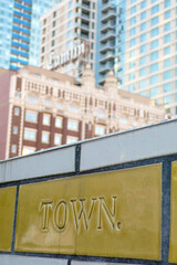 Fototapeta premium Tiled wall with typography and buildings in the background in downtown Seattle, USA