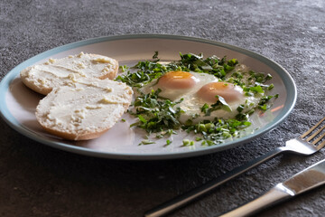 Fried eggs with greens close-up, healthy breakfast