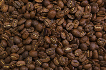 Background of coffee whole beans. A mixture of different types of coffee beans.