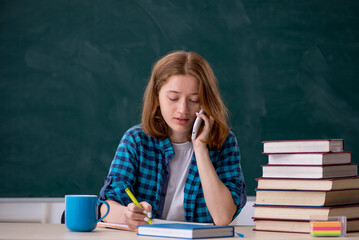 Young female student preparing for exams in the classroom